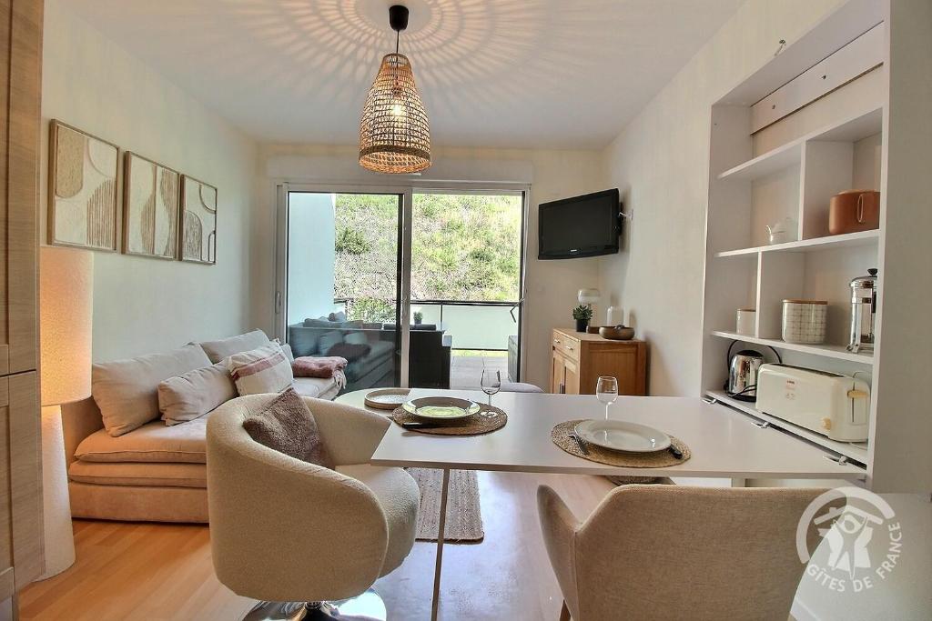 a living room with a table and a couch at Les bains in Pléneuf-Val-André