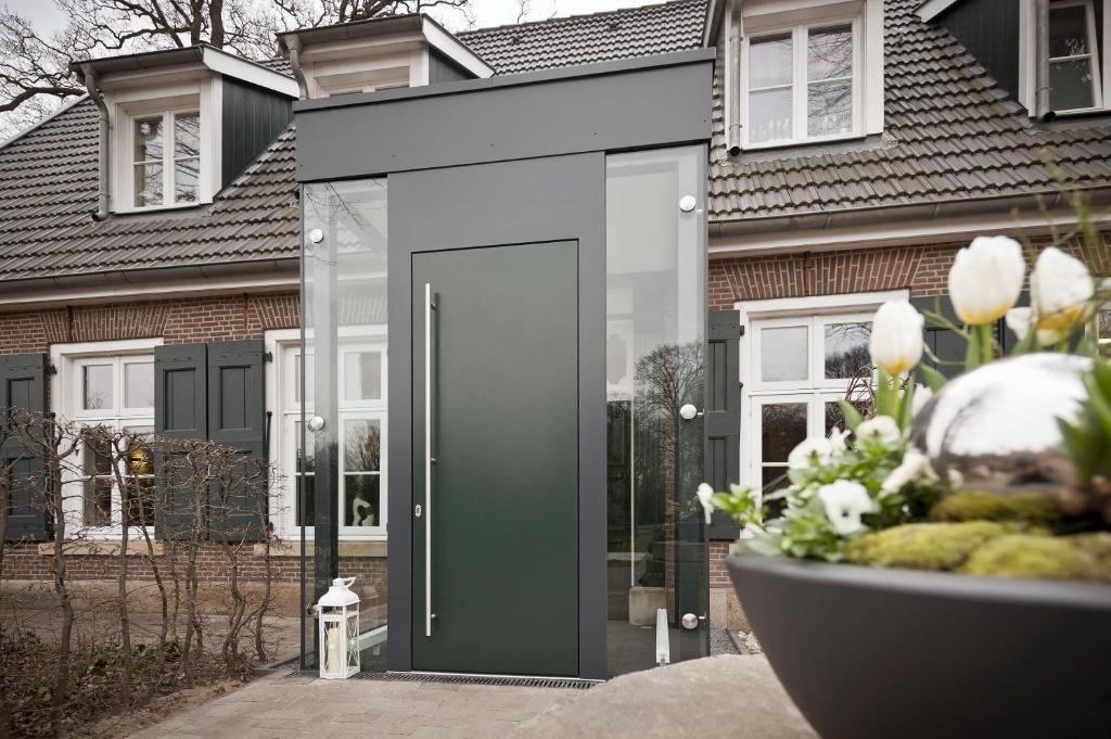 a house with a green door in front of it at Altes Landhaus Buddenberg in Kleinringe