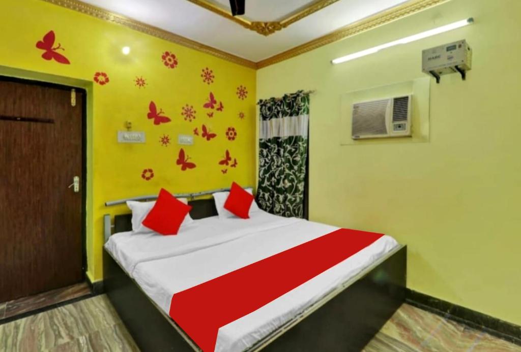 a bedroom with a bed with red pillows at PREMIUM THE BEST HOTEL Near Railway Station - Wifi and Fully Air Conditioning Room - Prime Location - Room Service and Excellent Customer Service Awarded in Bādshāhnagar