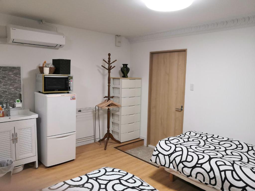 Säng eller sängar i ett rum på Nippori Osaka Nishi-Tengachaya Guesthouse西天下茶屋アパートメント