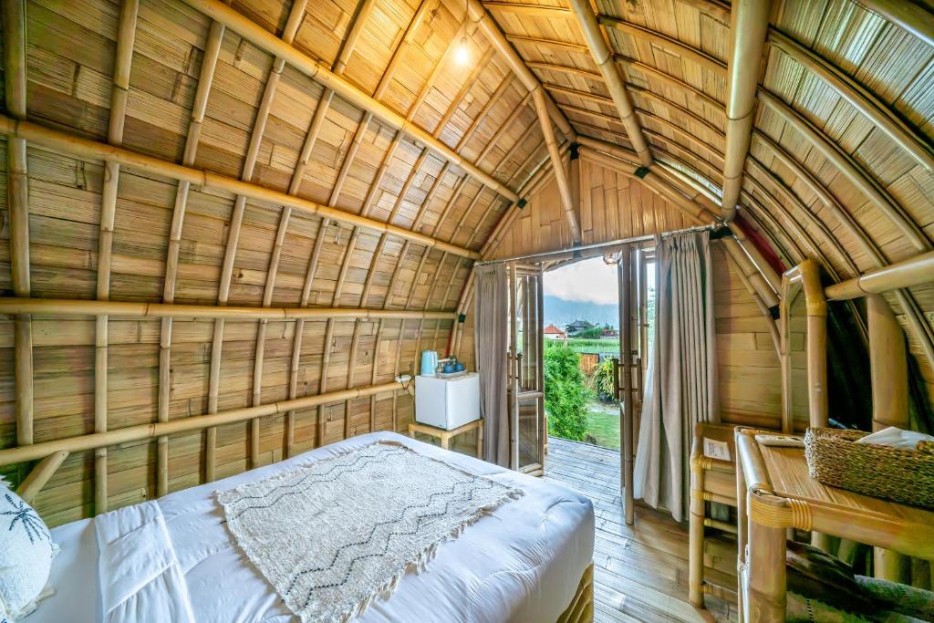 una camera con un grande letto in una stanza di bambù di Tegal Bamboo Cottages & Private Hot Spring a Baturaja