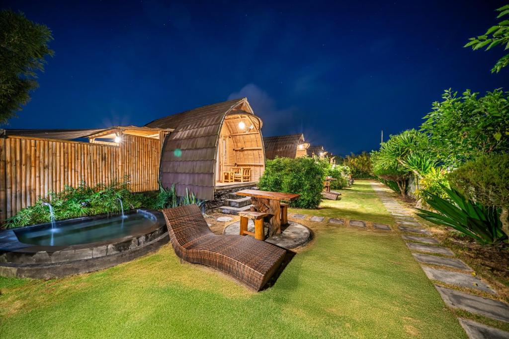 a backyard with a yurt and a table and chairs at Tegal Bamboo Cottages & Private Hot Spring in Baturaja