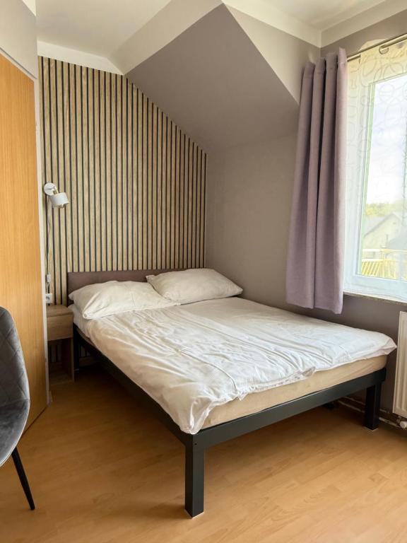 a bed in a small room with a window at Pensjonat Wiktoria in Międzywodzie