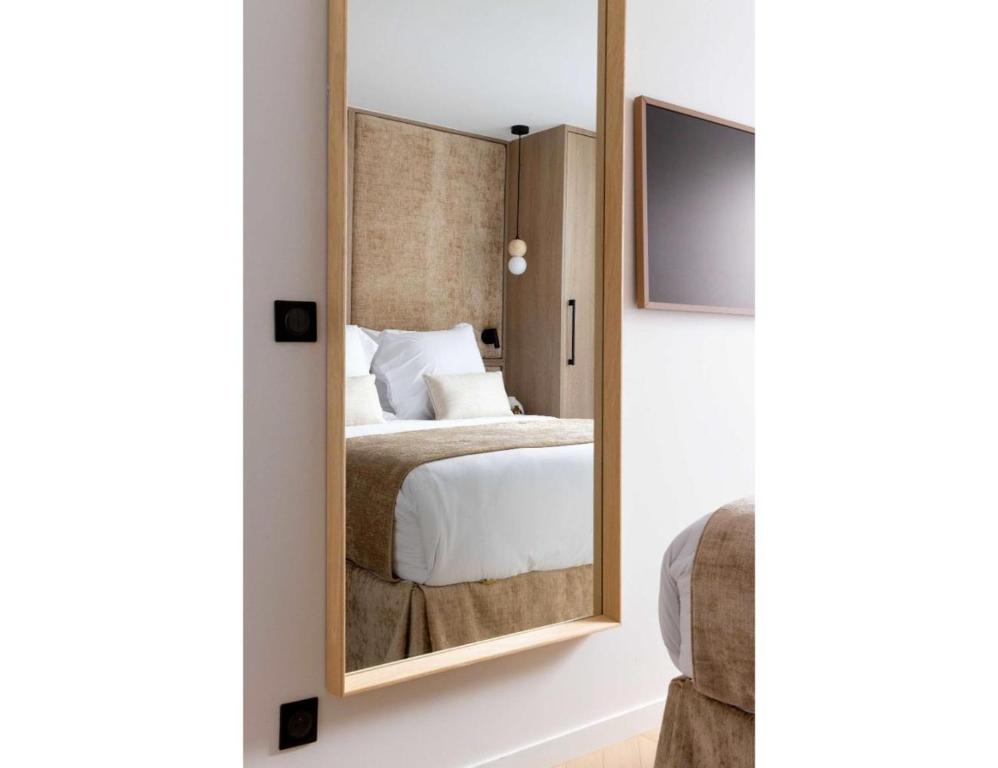 une chambre avec un lit et un grand miroir dans l'établissement Résidence SAINTE ELISABETH MARAIS, à Paris