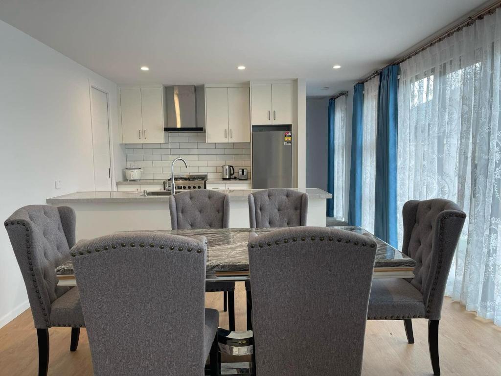 a kitchen with a dining room table and chairs at New Luxury House in Christchurch in Christchurch