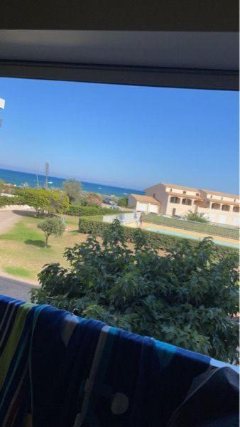 une fenêtre avec vue sur l'océan depuis une maison dans l'établissement Appartement aéré avec vue sur la mer , plage 50m et piscine 20m dans la résidence, au Barcarès