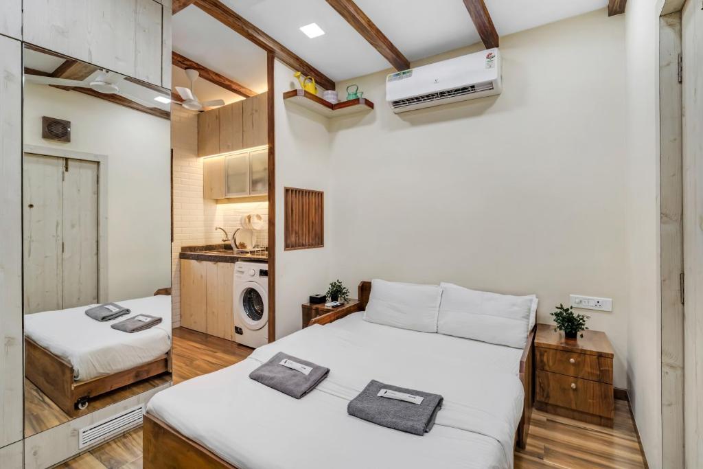 a small room with two beds and a kitchen at Pebble Studio Bandra W The Bombay Home Company - Eco in Mumbai