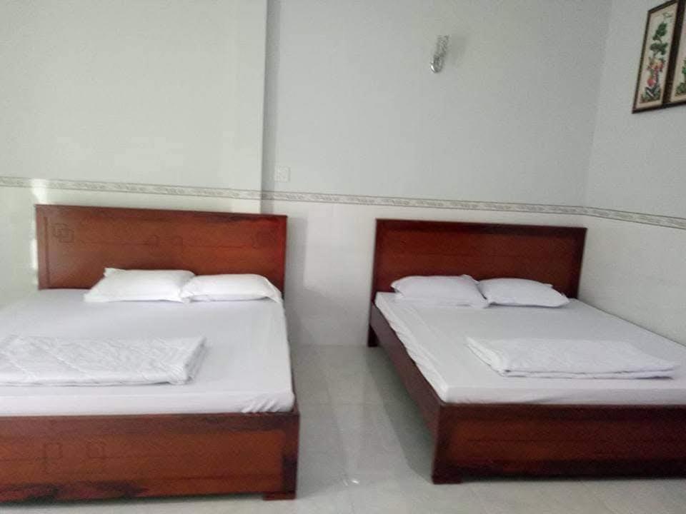 Dos camas una al lado de la otra en una habitación. en Nhà Nghỉ TRINH TÂM, en Ấp Thiện Phước