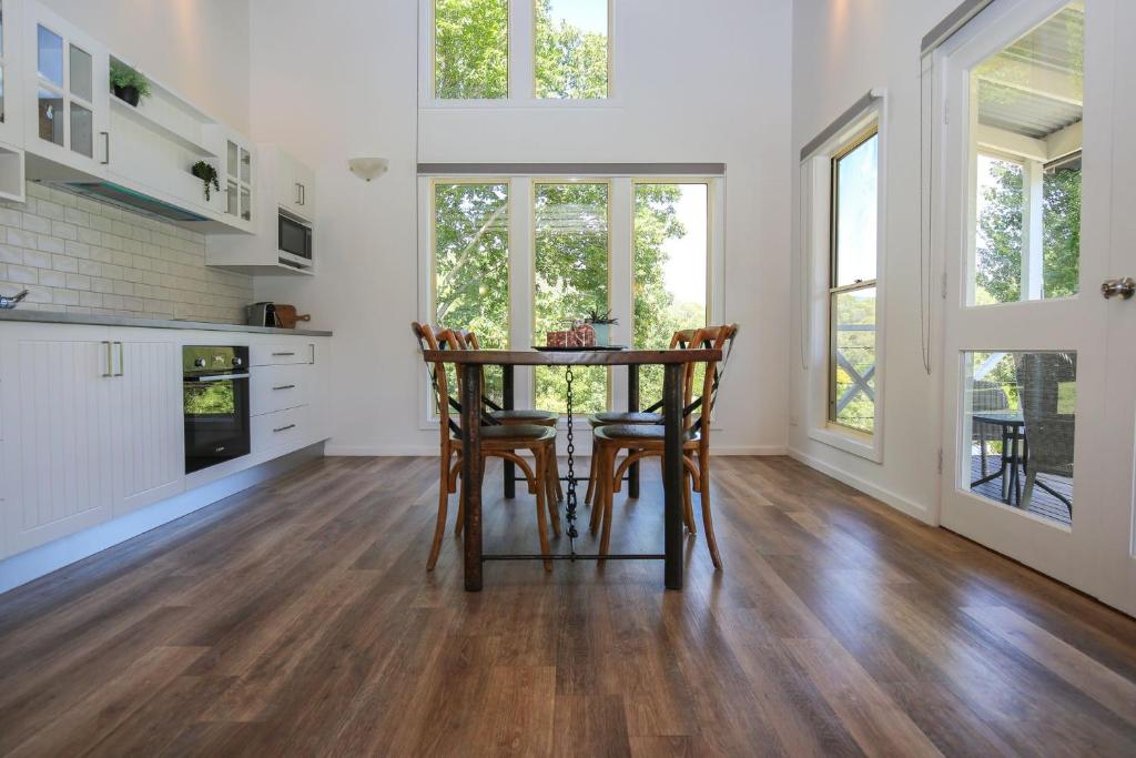 a kitchen and dining room with a table and chairs at Bonnie's Cottage - Peaceful retreat in Wandiligong