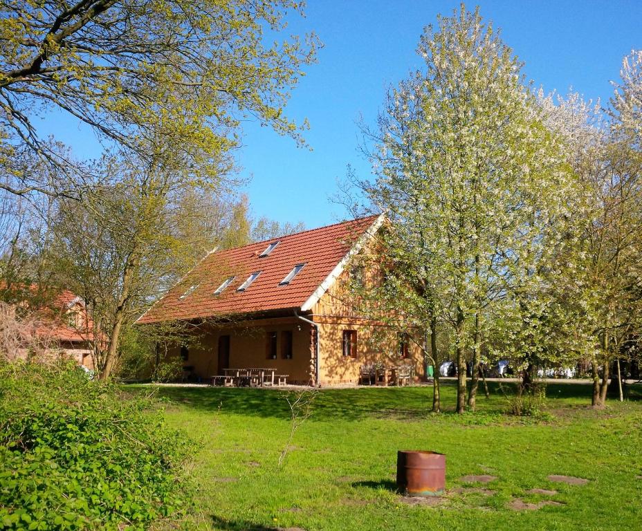 una casa con techo rojo en un campo verde en Ferienhof Idyll am kleinen Fließ en Burg (Spreewald)