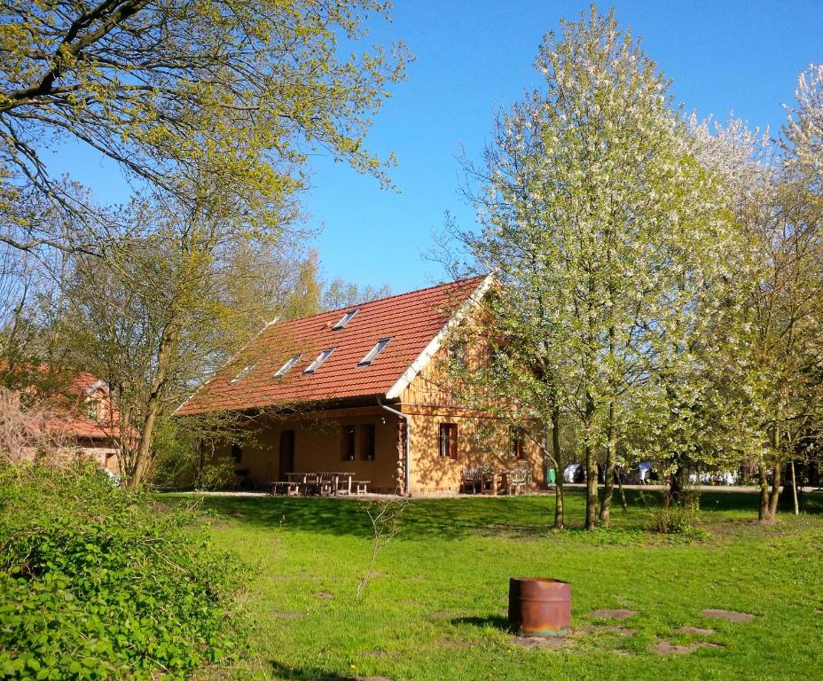 a house with a red roof on a green field at Ferienhof Idyll am kleinen Fließ in Burg