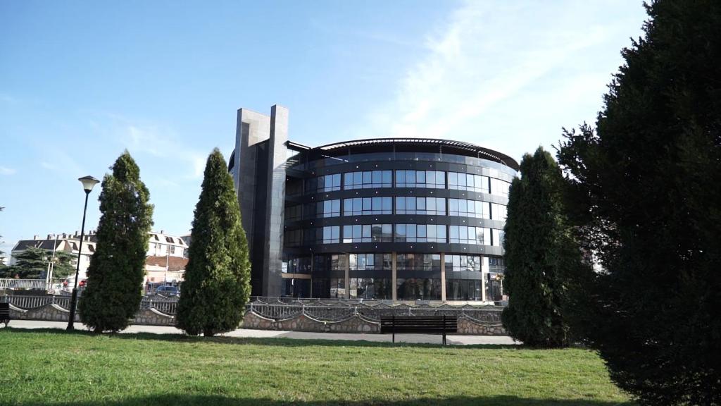 un gran edificio de cristal con árboles delante de él en Orbis Design Hotel & Spa, en Paraćin