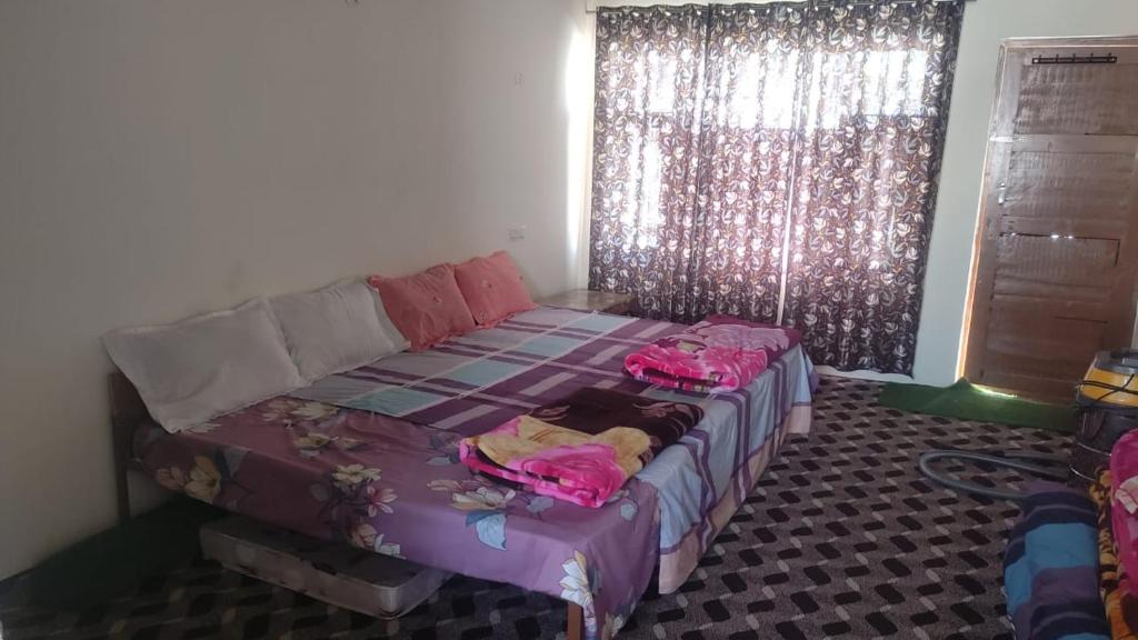 a room with a bed with two bags on it at Donmay homestay & guesthouse in Silapi