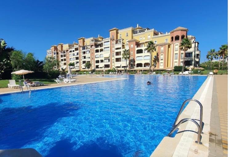 a large swimming pool in front of a large building at Canela Garden in Isla Canela