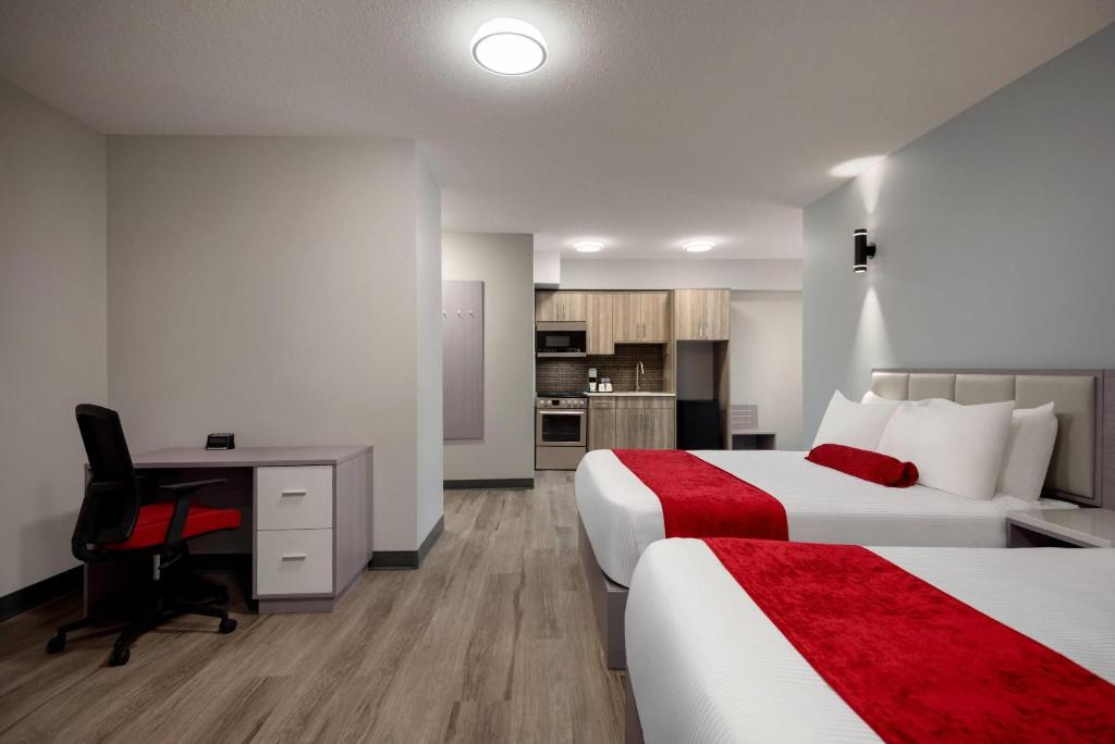 Postel nebo postele na pokoji v ubytování Ramada by Wyndham West Edmonton Hotel & Suites