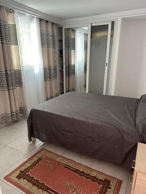 una camera da letto con un letto e un tappeto sul pavimento di Maison S1 a Mahdia