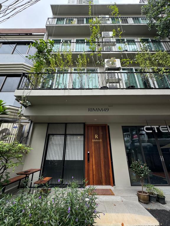a building with a wooden door and a balcony at Rimm49 Bangkok in Bangkok
