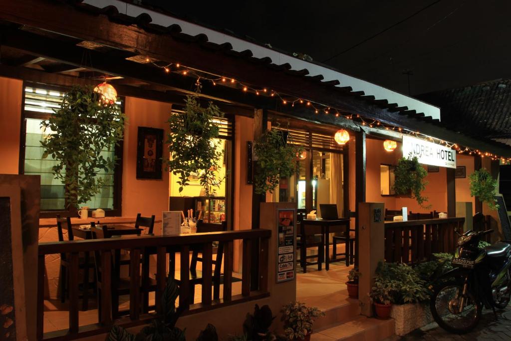 a restaurant with tables and chairs on a patio at night at Andrea Hotel in Yogyakarta