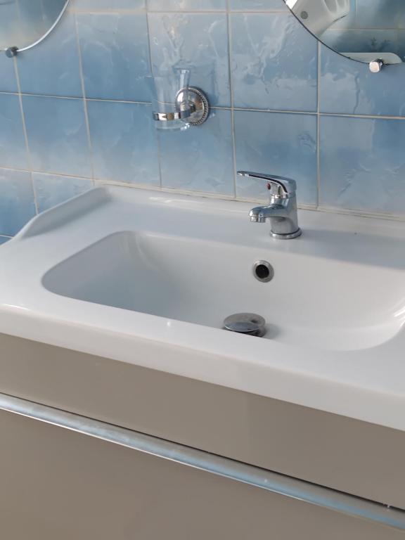 La salle de bains est pourvue d'un lavabo blanc et d'un robinet. dans l'établissement La Montagnarde, à Cézens