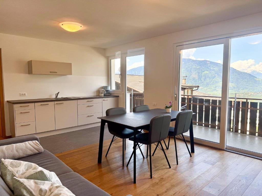 a kitchen and dining room with a table and chairs at Ferienwohnungen Preiss in Schenna