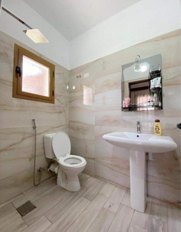 a bathroom with a sink and a toilet at Arlind's Apartaments in Vlorë
