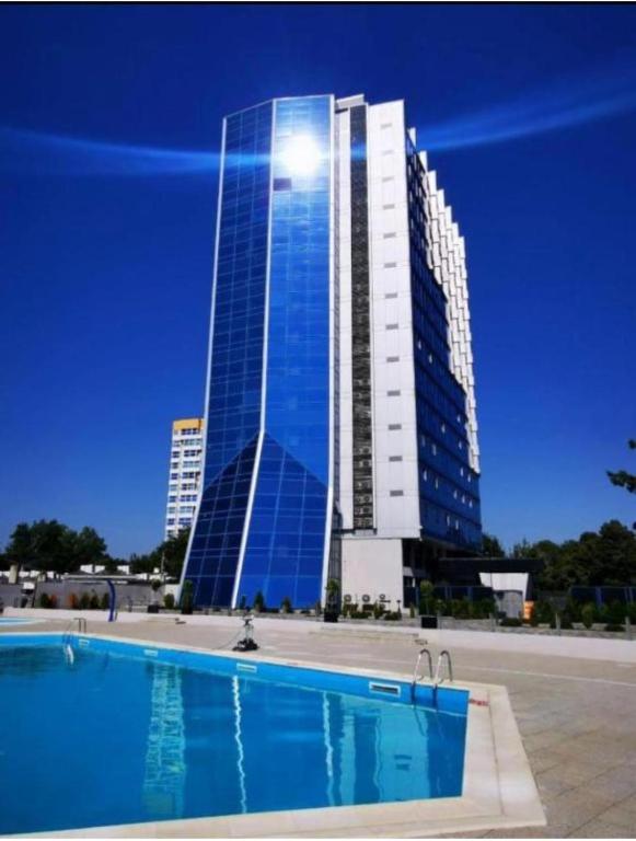 a tall building with a pool in front of it at Sea View Apartments Olimp Etajul 9 in Olimp