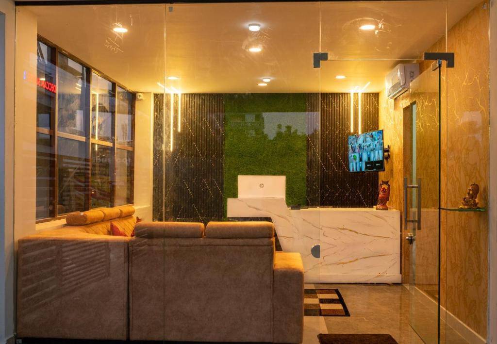 Una sala de estar con un sofá y un televisor. en Hotel Elite Fortune Inn, en Tirupati