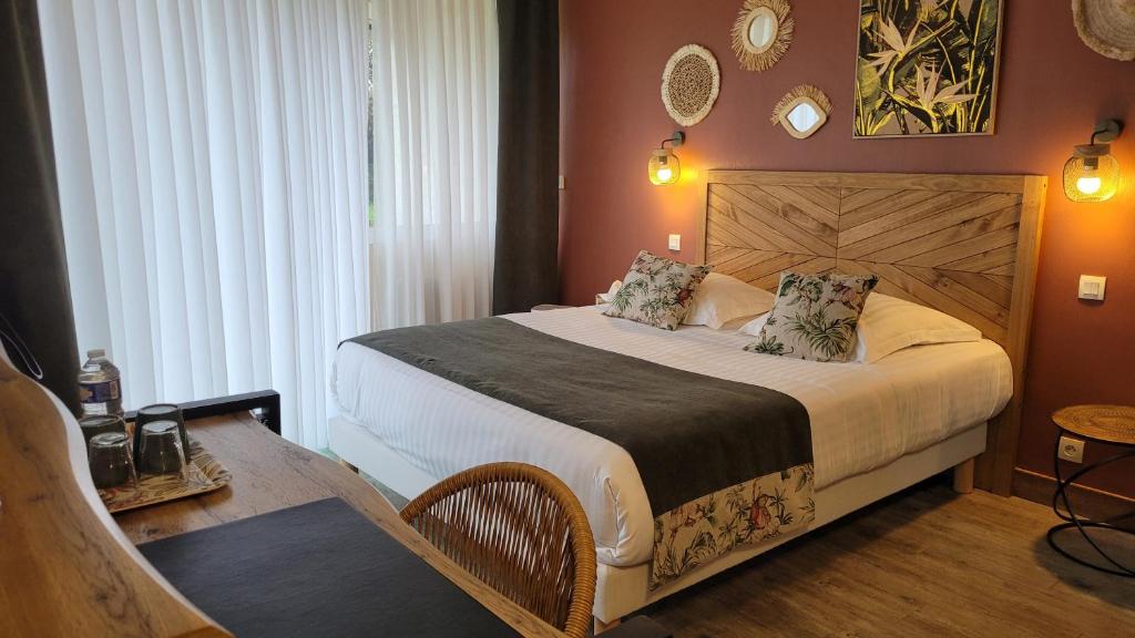 Postel nebo postele na pokoji v ubytování Logis Hotel La Croix du Sud