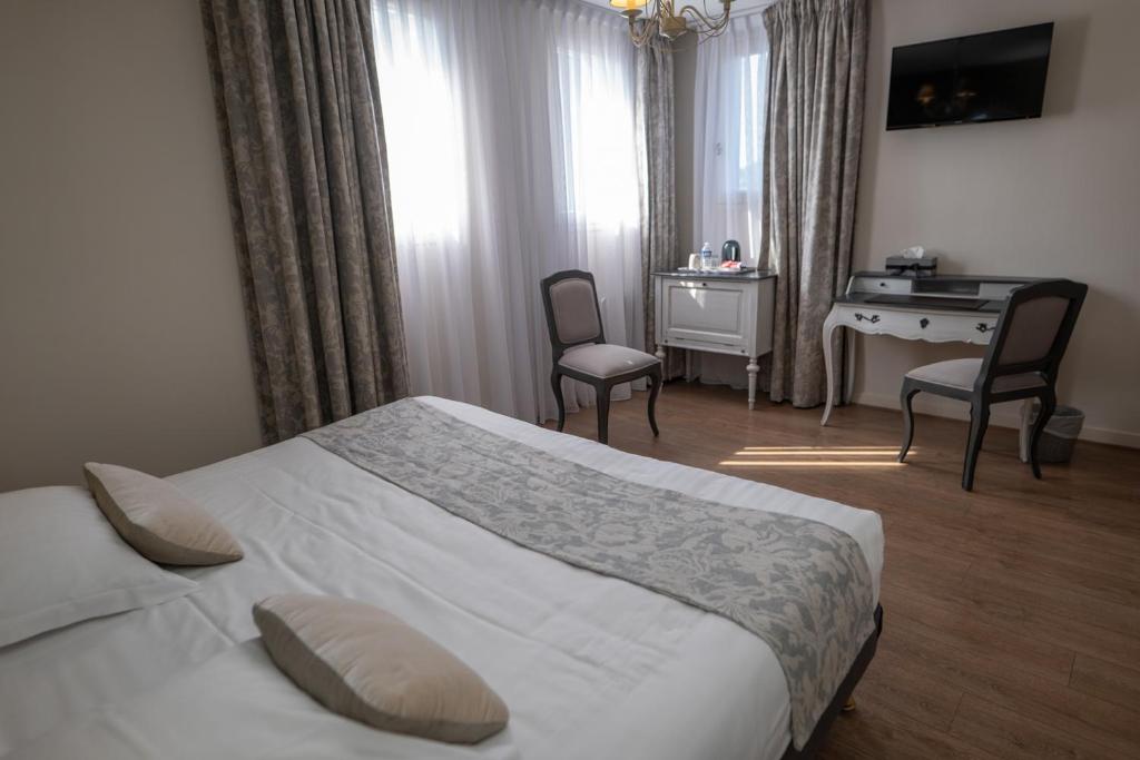 Postel nebo postele na pokoji v ubytování Logis Hotel La Croix du Sud