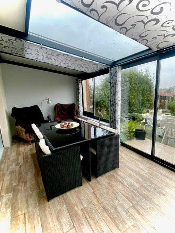 d'un salon avec une table et un balcon. dans l'établissement Maison Cléopâtre 4 minutes à pied de la plage 3 chambres véranda jardin parking privé, à Wimereux