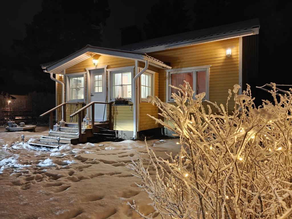 une petite maison dans la neige la nuit dans l'établissement Peaceful house for relaxing, à Oulu