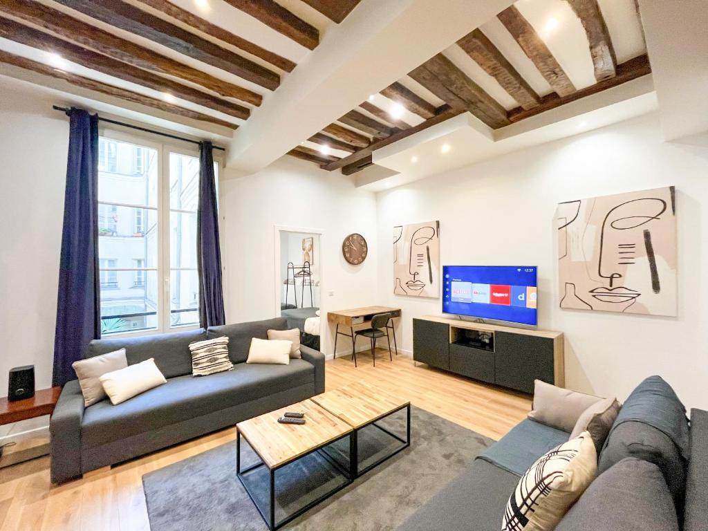 un salon avec un canapé et une télévision dans l'établissement Urban Flat 67 - Spacious Flat in Central Paris, à Paris