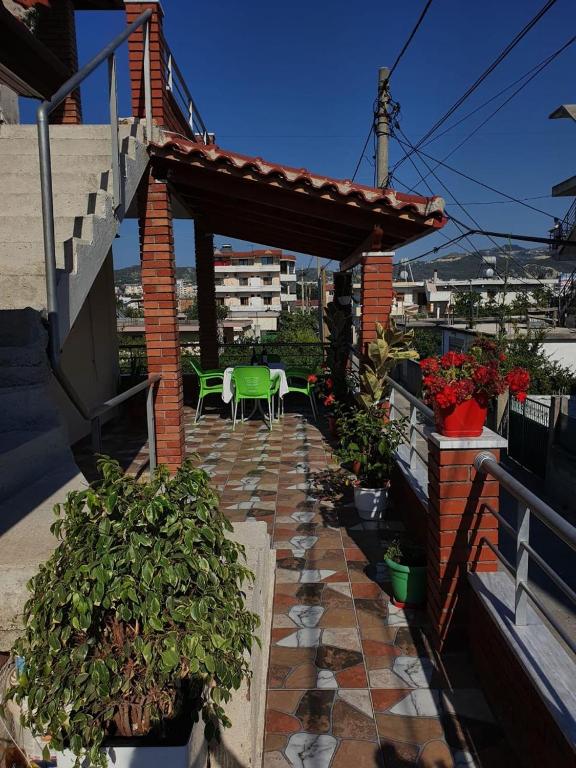 a patio with a table and chairs on a house at Arlind's Apartaments in Vlorë