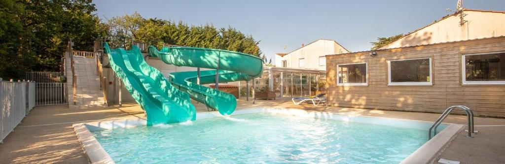 a blue water slide in a swimming pool at Camping les Alouettes - Bretignolles-sur-Mer in Bretignolles-sur-Mer