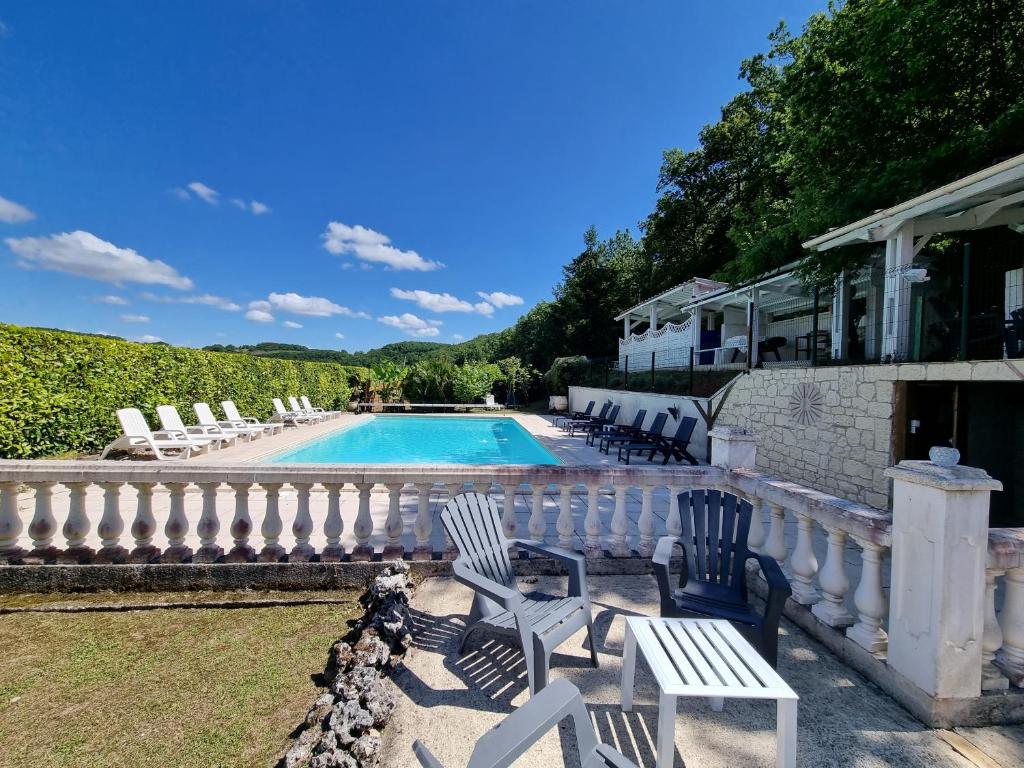 une piscine avec des chaises longues et une clôture dans l'établissement Les gites du Treil - 2 Grandes piscines privées- 9 chambres - 20 personnes, à Courbiac