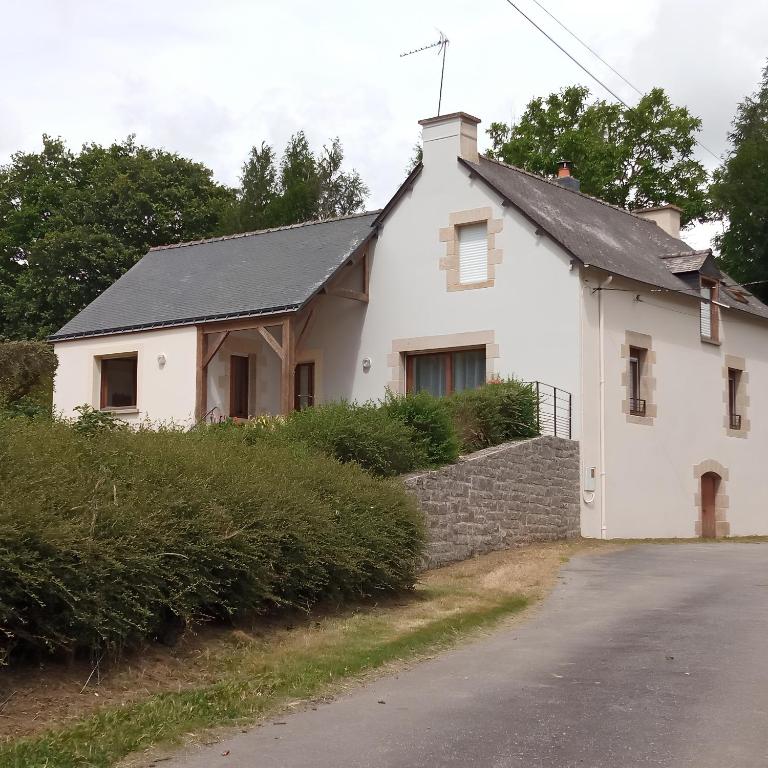 une maison blanche avec un toit noir et une rue dans l'établissement Maison à la campagne - Ploërmel, à Ploërmel