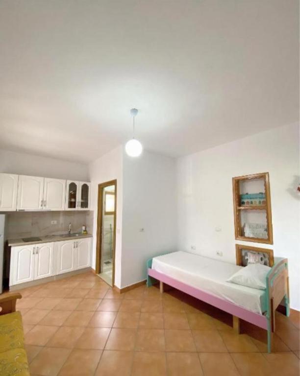 a living room with a bed and a kitchen at Arlind's Apartaments in Vlorë