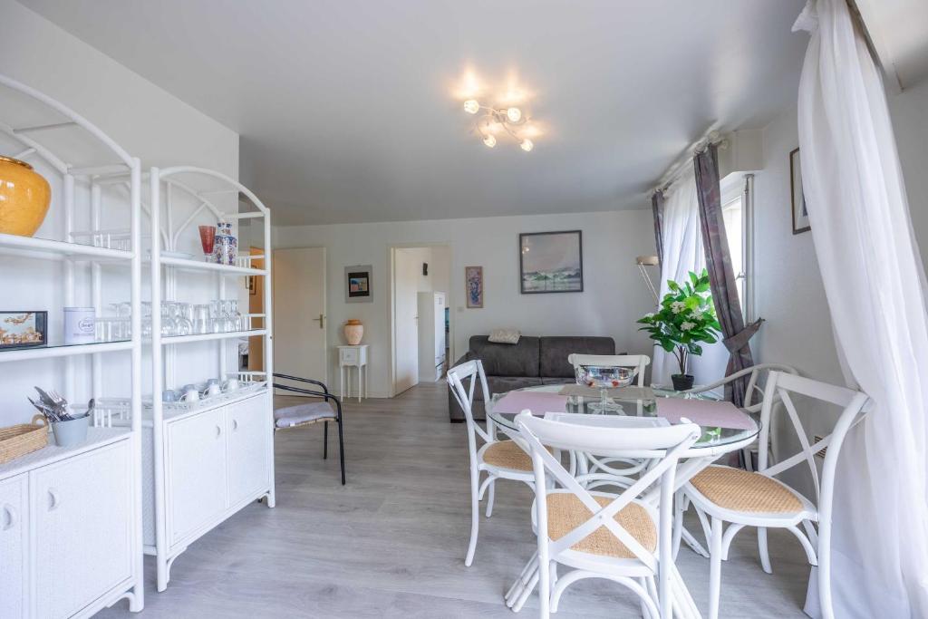 une cuisine et un salon avec une table et des chaises dans l'établissement Apartment with parking and balcony near the beach, à Deauville