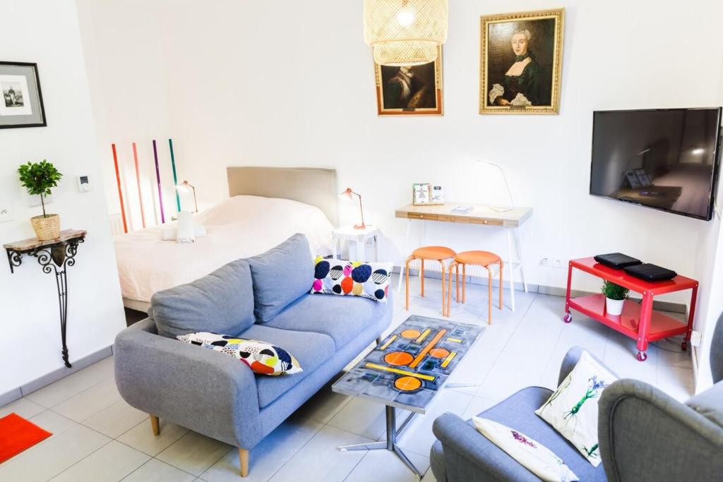 - un salon avec un canapé bleu et un lit dans l'établissement Studio with Garage Near Perrache Train Station Lyon City Center, à Lyon