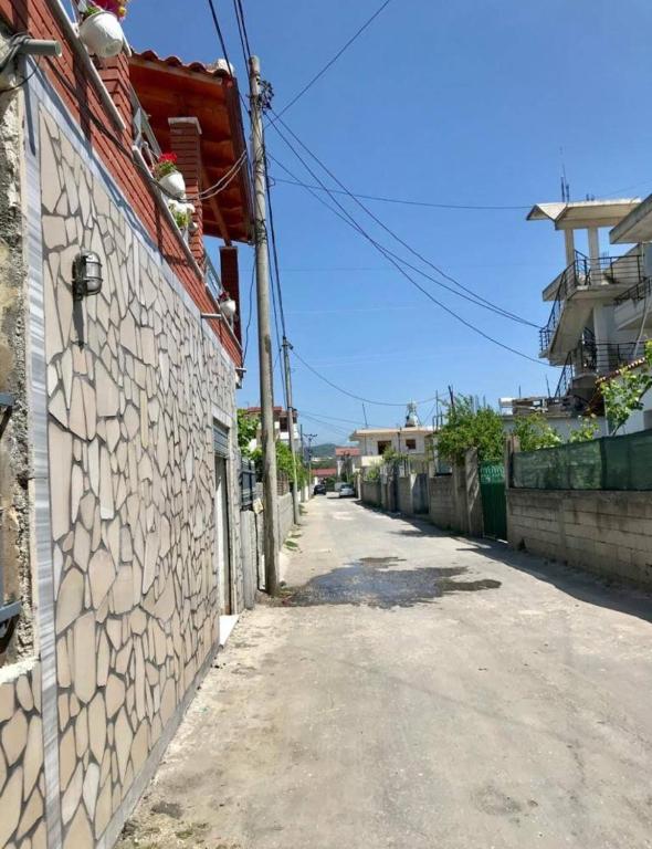 an empty alley with a stone wall and a building at Arlind's Apartaments in Vlorë