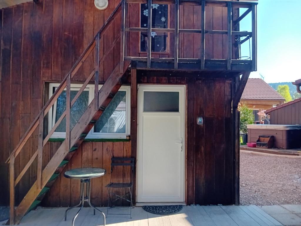 a house with a staircase and a door and a stool at chambre studio in Gérardmer