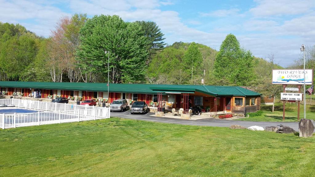 a building with cars parked in a parking lot at Two Rivers Lodge in Bryson City