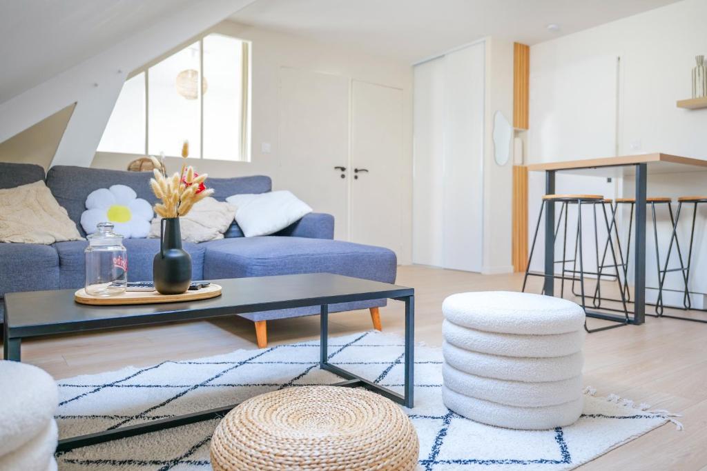 un salon avec un canapé bleu et une table dans l'établissement Très bel appartement lumineux et au calme - 2 personnes, à Angers