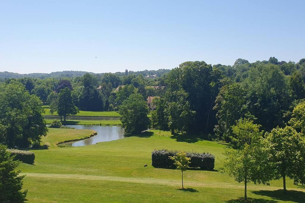 un champ verdoyant avec une rivière au milieu dans l'établissement Plage et Golf !, à Houlgate