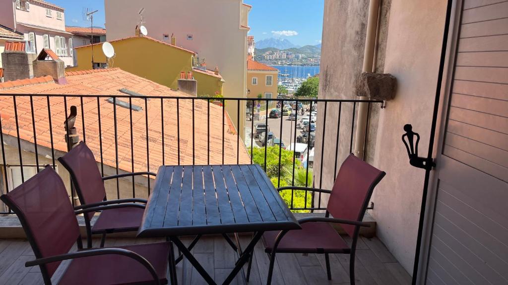 une table et des chaises sur un balcon avec vue dans l'établissement forcioli conti T2 tout confort, à Ajaccio