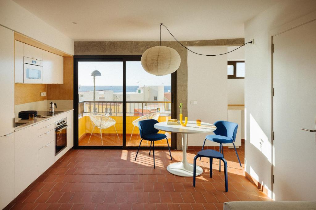 a kitchen and dining room with a table and chairs at Hidalga Piso con terraza y vistas al mar in Puertito de Güímar