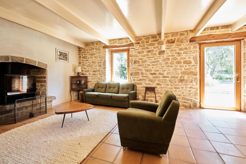 un salon avec deux canapés et une cheminée dans l'établissement Longère de charme, Mousterlin, à Fouesnant