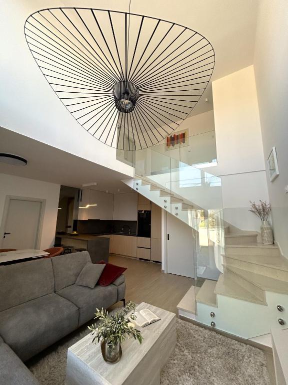 a large chandelier hangs from the ceiling of a living room at Villa Maksan - Sea View, Jacuzzi & BBQ Garden in Pakoštane