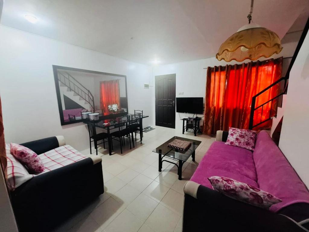 ein Wohnzimmer mit Sofa und Tisch in der Unterkunft Home in the Historic City Entire House with 3 beds in Lapu Lapu City
