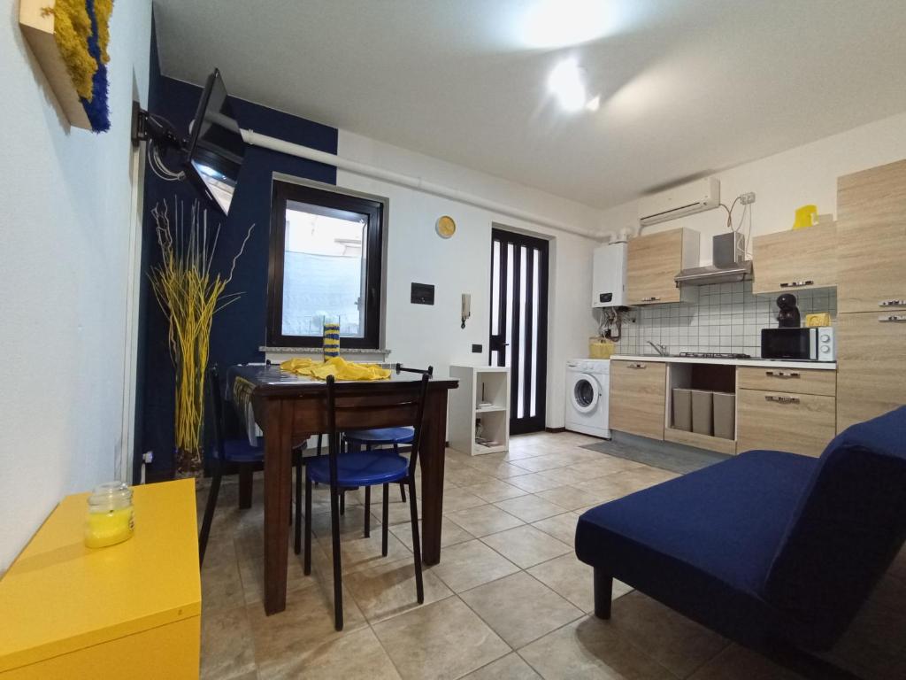 a living room with a dining room table and a kitchen at Ortacolorhome BlueHome-Boleto in Madonna del Sasso